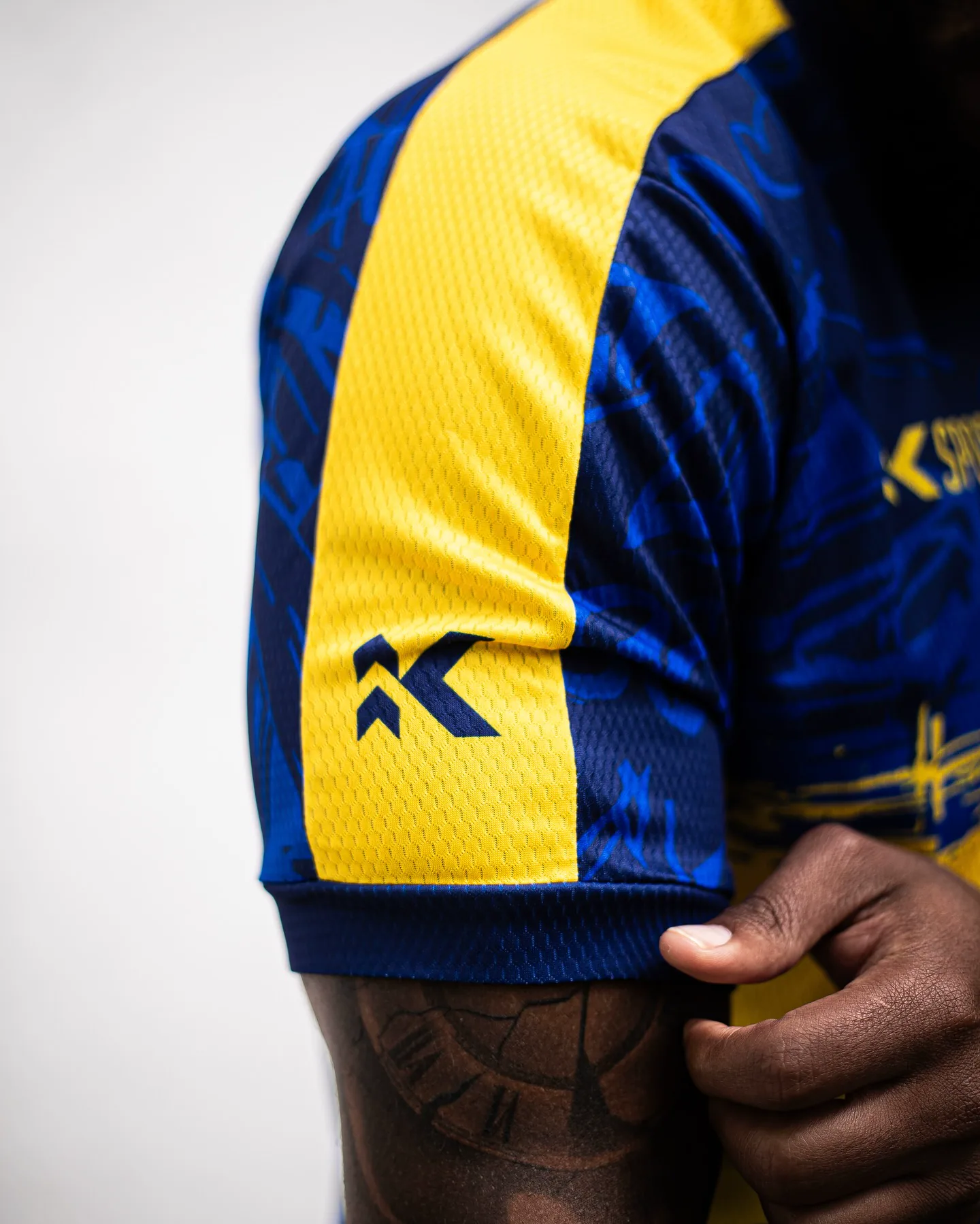 Textura colmeia e faixa no ombro da camisa FUSION